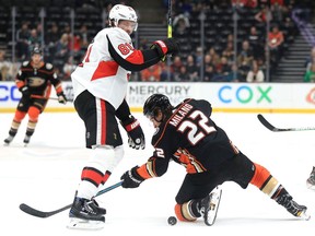 Ron Hainsey of the Ottawa Senators battles Sonny Milano of the Anaheim Ducks for a loose puck during the first period of a game at Honda Center on Tuesday in Anaheim, California.