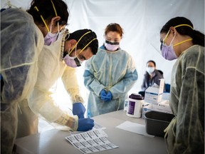 Doctors test hospital staff with flu-like symptoms for coronavirus (COVID-19) in set-up tents to triage possible COVID-19 patients outside before they enter the main Emergency department area at St. Barnabas hospital in the Bronx on March 24, 2020 in New York City. New York City has about a third of the nations confirmed coronavirus cases, making it the center of the outbreak in the United States.