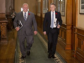 Ontario Finance Minister Rod Phillips (right) is accompanied by Ontario Premier Doug Ford as they walk to the Ontario legislature to deliver the fall economic statement on Nov. 6, 2019. (The Canadian Press)