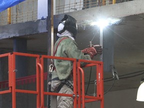 A construction worker welds at a job site in the Queen St. E.-Greenwood Ave. area on March 23, 2020. (Jack Boland, Toronto Sun)