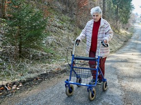 Gertrude Fatton, walks outside her house after her return from the hospital during the coronavirus disease (COVID-19) outbreak in Le Locle, Switzerland, March 27, 2020. (REUTERS/Denis Balibouse)