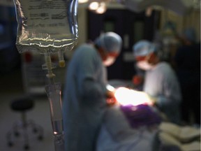 FILE: Doctors and healthcare staff in an operating room.