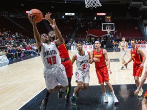 Alain Louis of the Carleton Ravens goes to the basket against Ezeoha Santiago of the Calgary Dinos in a men's quarterfinal of the U Sports Final 8 basketball championships at the arena at TD Place in Ottawa on fRiday, March 6, 2020.