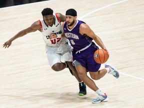 Carleton's Alain Louis applies defensive pressure on Western's Eriq Jenkins during Saturday's semifinal at TD Place arena.