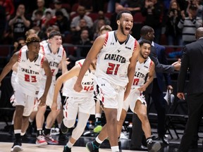 Biniam Grebrekidan (21) leads the charge as Ravens players start to celebrate Sunday night's 74-65 victory against the Tigers.