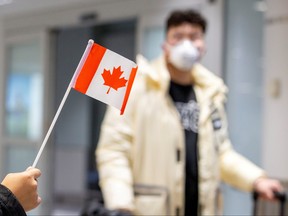 A traveller wears a mask at Pearson airport arrivals, shortly after Toronto Public Health received notification of Canada's first presumptive confirmed case of novel coronavirus, in Toronto, Ontario, Canada January 26, 2020. (REUTERS/Carlos Osorio/File Photo)