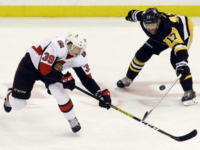 Ottawa Senators defenceman Andreas Englund and Pittsburgh Penguins right wing Bryan Rust each for the puck during the second period at PPG PAINTS Arena on March 3, 2020.