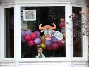 Alice sits by her decorated window at home in Ottawa Tuesday March 24, 2020. Ottawa parents and kids cooped up at home are participating in artistic scavenger hunts suitable for a pandemic.