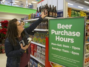 Erin Anderson of London looks over a selection of craft beers at the Oakridge Superstore in London, Ont. on December 15, 2015. (Mike Hensen/The London Free Press)