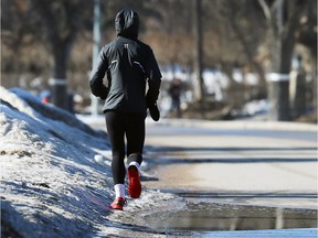 A jogger dodges a puddle and some of the season's last remaining snow.