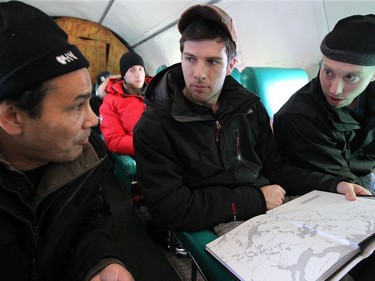DELINE, N.W.T. NOVEMBER 19,  2012 --- Ottawa goalie Craig Anderson (right) and Jody O'Neil get some northern history from a fellow passenger on a plane.   Hunting, dogsledding and dancing kept NHLers busy during their visit to Deline Monday and Tuesday. The small native community of 600 people is the birthplace of hockey, where skating with stick was first recorded in 1825.