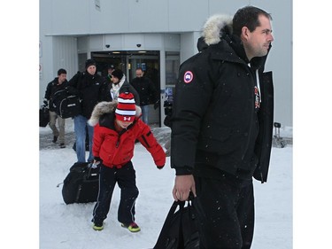YELLOWKNIFE, N.W.T. NOVEMBER 18,  2012  Here, Chris Phillips, followed by his young son, Ben, 9, walks to the waiting bus from the airport with the other players.