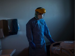 FILE: Medical staff attend a patient infected with COVID-19.