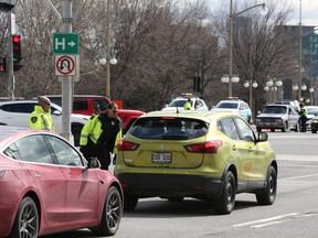 Gatineau Police officers control the traffic leaving Gatineau for Ottawa as well as vehicles entering Gatineau from Ottawa at the Portage Bridge on Monday.