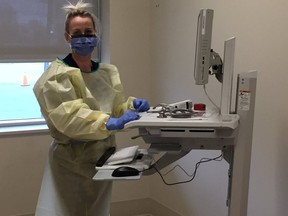 A nurse in personal protective equipment works at the Cornwall COVID-19 assessment centre in Cornwall, Ont. (Postmedia Network photo)