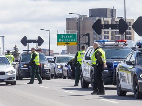 Sûreté du Québec stop vehicles on the Macdonald-Cartier Interprovincial Bridge as they enter Gatineau on April 1, 2020.