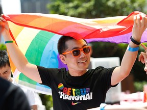 This file picture taken on June 17, 2017 shows a man holding a rainbow flag after taking part in the Pride Run in Shanghai. (STR/AFP/Getty Images)