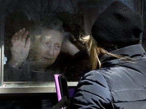 Diane Colangelo visits her 86-year-old mother Patricia through a window at Orchard Villa long-term care home in Pickering on Wednesday, April 22, 2020.