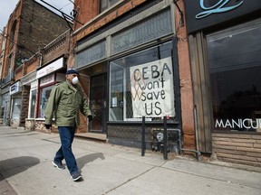 A closed store front boutique business called Francis Watson pleads for help displaying a sign in Toronto on Thursday, April 16, 2020.