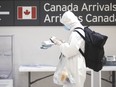 A traveller stands in the International arrivals hall at Toronto's Pearson Airport, on Friday, March 27, 2020.