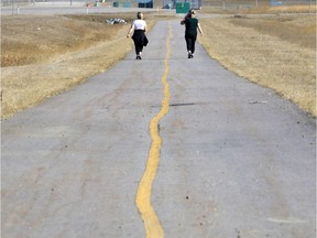 Two people take a walk in Calgary during the COVID-19 pandemic on April 21, 2020.