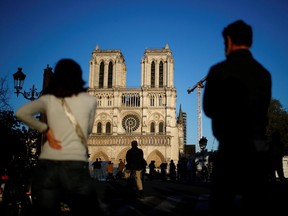 People listen to the Notre-Dame de Paris Cathedral's great bell ringing, as a mark of the building's resilience one year after a devastating fire, during the coronavirus disease outbreak, April 15, 2020.