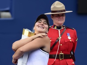 Bianca Andreescu of Canada hugs the winner's trophy after Serena Williams had to retire from the final of the Rogers Cup in Toronto on Sunday, Aug. 11, 2019. (THE CANADIAN PRESS/Frank Gunn)