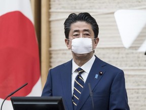 Japan's Prime Minister Shinzo Abe wears a face mask as he attends a press conference at the prime minister's official residence on Tuesday, April 7, 2020 in Tokyo, Japan.