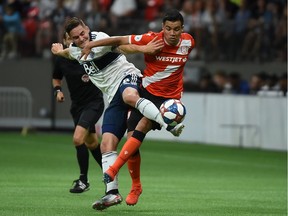 Jake Nerwinski of Whitecaps reaches for the ball against Cavalry FC midfielder Jose Escalante during their Canadian Championship match at B.C. Place Stadium in Vancouver last year. The CPL's Cavs have been faced with the prospect of a wage deferral this week, while MLS players could be in the same boat soon enough.
