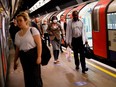 A commuter, wearing PPE (personal protective equipment) as a precautionary measure against COVID-19, walks along the platform at a tube station in London on April 22, 2020, as Britain remains under lockdown during the COVID-19 pandemic.