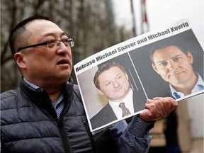 FILE PHOTO: Louis Huang holds a placard calling for China to release Canadian detainees Michael Spavor and Michael Kovrig outside a court hearing for Huawei Technologies Chief Financial Officer Meng Wanzhou at the B.C. Supreme Court in Vancouver on March 6, 2019.