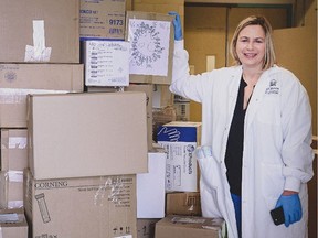 Gillian Lord, director of strategic planning and implementation, faculty of medicine, stands beside a mountain of donated medical supplies.