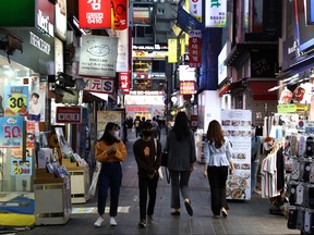 People walk along the street in face masks on May 6, 2020 in Seoul, South Korea.