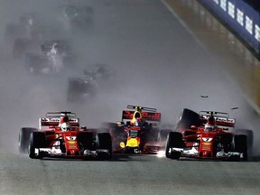 Sebastian Vettel of Germany driving the (5) Scuderia Ferrari SF70H, Max Verstappen of the Netherlands driving the (33) Red Bull Racing Red Bull-TAG Heuer RB13 TAG Heuer and Kimi Raikkonen of Finland driving the (7) Scuderia Ferrari SF70H are caught up in a crash at the start during the Formula One Grand Prix of Singapore at Marina Bay Street Circuit on September 17, 2017 in Singapore.