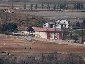 A general view shows people, fields, and buildings of the North Korean countryside outside Kaesong, seen across the Demilitarized Zone (DMZ) from the South Korean island of Ganghwa on April 23, 2020.