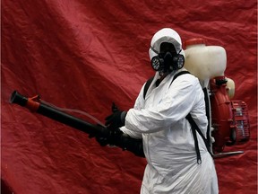 A cleaning worker wearing personal protective equipment (PPE) disinfects Jamaica Market in Mexico City, on May 23, 2020.