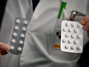 Medical staff shows packets of a Nivaquine, tablets containing chloroquine and Plaqueril, tablets containing hydroxychloroquine, drugs that has shown signs of effectiveness against coronavirus, at the IHU Mediterranee Infection Institute in Marseille, France, on Feb. 26, 2020.
