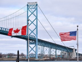 Canadian and American flags fly near the Ambassador Bridge at the Canada-USA border crossing in Windsor, Ont. on Saturday, March 21, 2020.