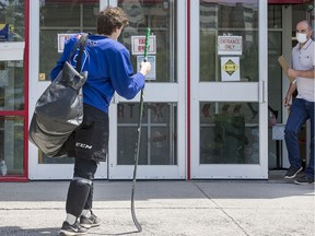 A young hockey player waits for the doors to open as players take advantage of ice time with skating coach Shelley Kettles at the Minto Arena on Thursday, May 21, 2020.