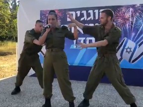 In this video screengrab, two soldiers dance behind Israeli pop star Noa Kirel.
