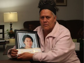 A file image shows Caroline Letourneau holding a photo of her son, Issaiah Clachar, who died after being stabbed on Sept. 20, 2015.