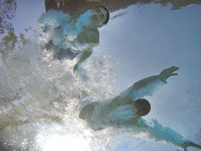 Brothers Alex and Carter Dalipaj cool off swimming in their pool during a heat wave in Ottawa on Wednesday.