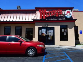 A vehicle pulls into the drive-thru lane at a Wendy's fast food restaurant in Alhambra, California on May 5, 2020.