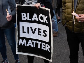 A person holds a Black Lives Matter sign during a vigil.