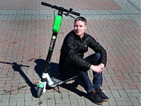 Spokesman Chris Schafer sits on the Lime electric scooter.