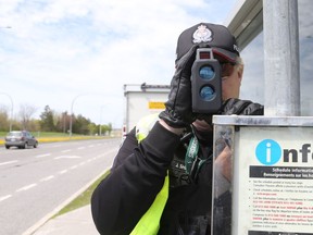 An Ottawa police officer uses a radar gun.