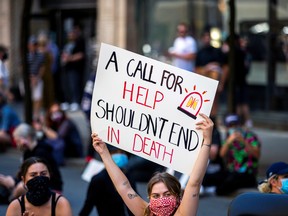 A demontrator holds a placard as she takes part in an "Abolish the police" sit in to mark Juneteenth, which commemorates the end of slavery in Texas, two years after the 1863 Emancipation Proclamation freed slaves elsewhere in the United States, amid nationwide protests against racial inequality in Toronto, June 19, 2020.