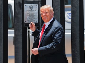 U.S. President Donald Trump smiles as he prepares to autograph a plaque commemorating the construction of the 200th mile of border wall while visiting the wall on the U.S.-Mexico border in San Luis, Ariz., June 23, 2020.