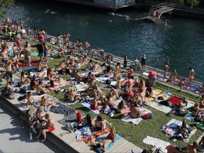 People enjoy hot summer weather on the banks of the Limmat river, as the spread of the coronavirus disease continues, in Zurich, Switzerland June 27, 2020.