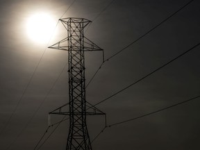 The sun sets behind hydro wires.